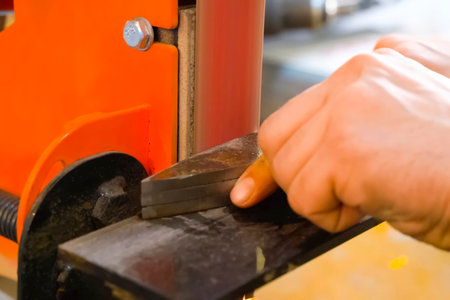 Sharpening a throwing knife on a grinding machine.