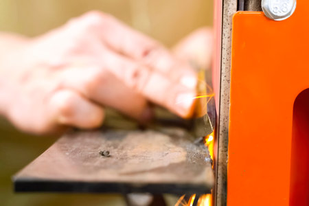 Sharpening a throwing knife on a grinding machine.の写真素材