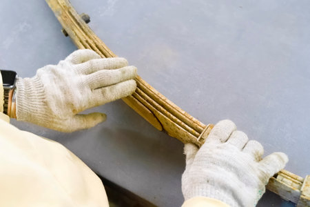 Old rusty truck springs in the hands of a man wearing gloves.の写真素材