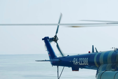Tail section of a helicopter, rear rotor against the sea horizon.