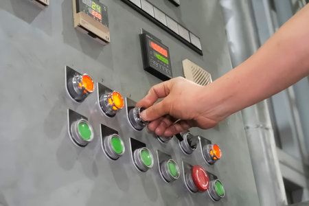 The operator presses his finger on the buttons on the wall control panel of the metalworking machine...