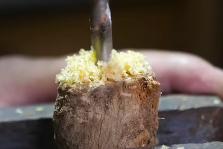 Drilling in a wooden piece clamped in a vice. A drill bit on wood drills woodの写真素材