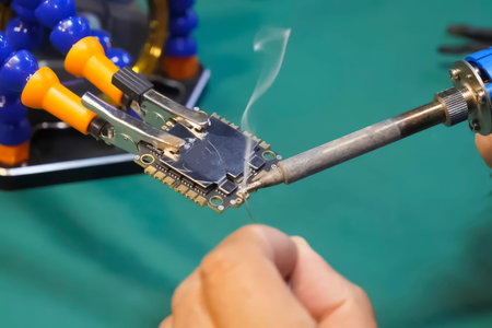 Soldering the contacts on the board with a microchip to connect the power wires. Microchip for FPV Droneの写真素材