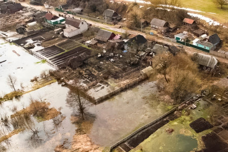 The river, overflowing its banks, floods the gardens and houses of the village, local flooding.の写真素材