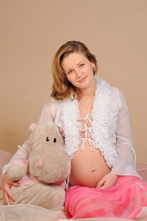The pregnant woman embraces a toy hippopotamus with a tummyの写真素材