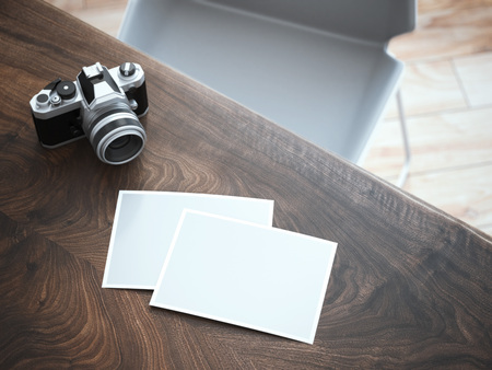 stylish camera and blank photos on wooden table. 3d renderingの写真素材