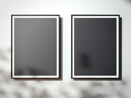 Blank black canvases on the white wall with shadows. 3d renderingの写真素材
