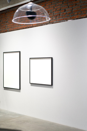 White blank canvas posters on the wall in modern bright art gallery.の写真素材