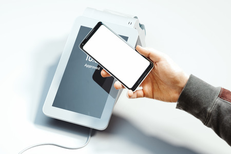Hand holding mobile phone and POS payment terminal NFC payments. 3d rendering.