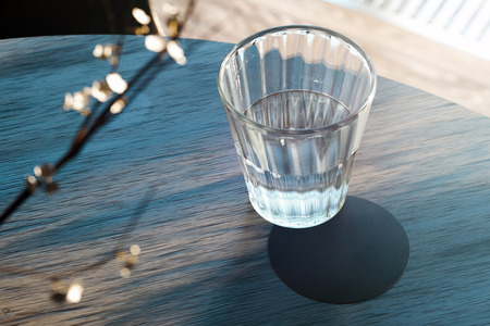 Transparent glass with water and beer coaster on wooden table. 3d rendering.
