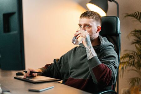 Young attractive man working on Graphics tablet. Modern working place of designer, painter,...