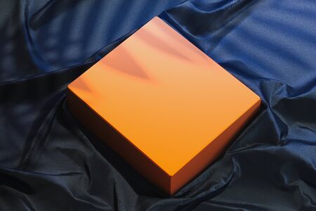 Close up of orange blank box on dark tissue. Copy space. Empty space. 3d rendering.