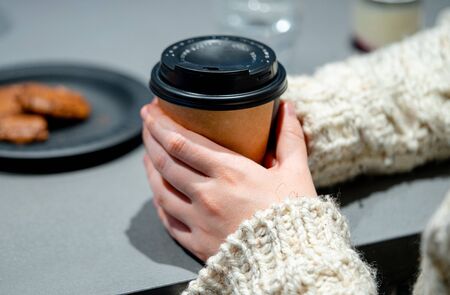 Woman Holding Biodegradable Cup With Coffee At Modern Bright Cafe. Concept Of Eco Friendly Treatmentの写真素材