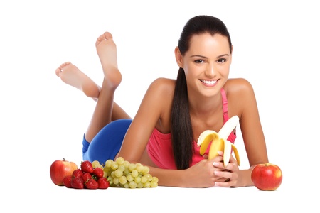 nice young woman lying on the floor with healthy fruitsの写真素材