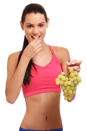 cute young woman posing with grapes on white backgroundの写真素材