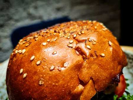 Close-up of hamburger with sesame seeds on the tableの写真素材