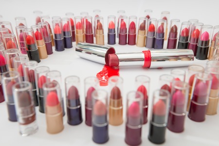 The concept of crime. Big lipstick in a pool of blood surrounded by many small gawkersの写真素材