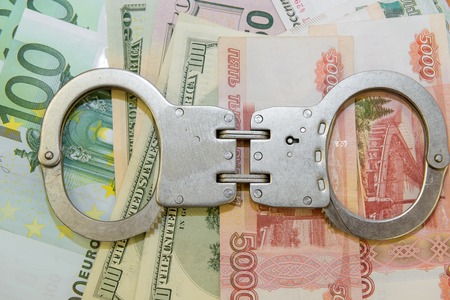 Crime and Money. Handcuffs are on the dollar, euro and rubleの写真素材