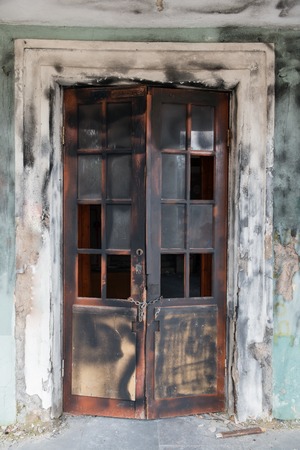 Scorched broken door of abandoned houseの写真素材