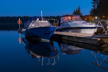Motor boats rest at night tied to the pier