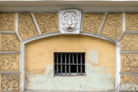 RUSSIA, SAINT PETERSBURG: Plaster head of a lion on the facade above a window with a latticeの写真素材