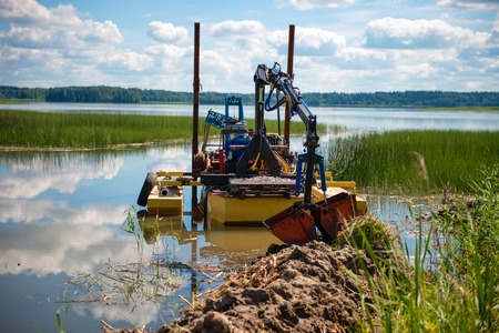 Cleaning the bottom of the lake with a dredgeの写真素材