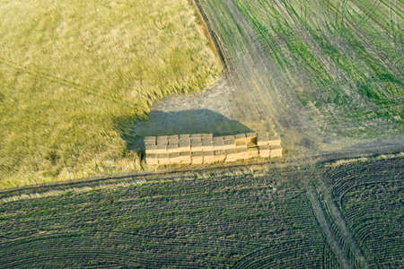 Aerial view of stacked haystack on agricultural field on autumn day