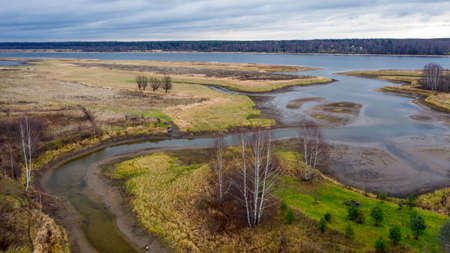 Aerial view of beautiful curving river at sunrise in autumn. view from air. Turns of river, meadows,...