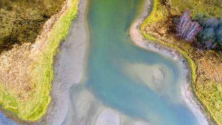 Aerial view of beautiful curving river at sunrise in autumn. view from air. Turns of river, meadows,...