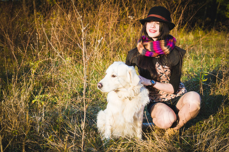 Girl in hat with dog in park have fun