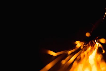 Bokeh lights on black background, shot of flying fire sparks in the airの写真素材