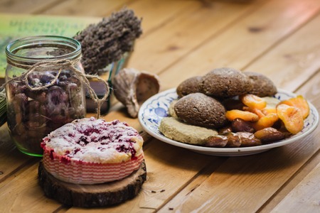 the composition of the household biscuits with cherries, nuts and dried fruits on wooden tableの写真素材