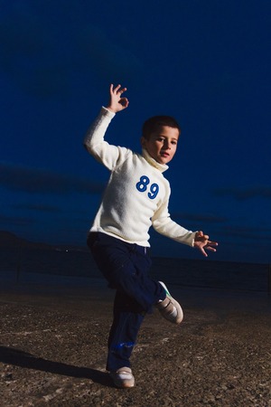 little dancer showing his skills on dark streetの写真素材