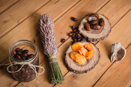 dried fruits on wooden plates with lavender on wooden tableの写真素材