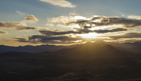 Sun rays lits thru the clouds over the valley on the duskの写真素材