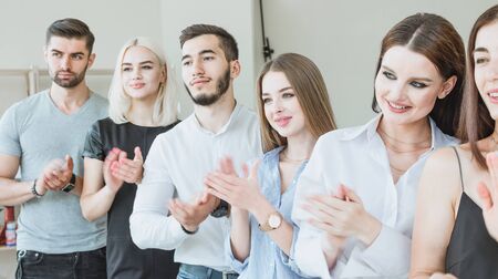 Young team applauding while standing in the officeの写真素材