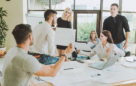 The working process. Casually dressed employees in the process of discussion of the project are...