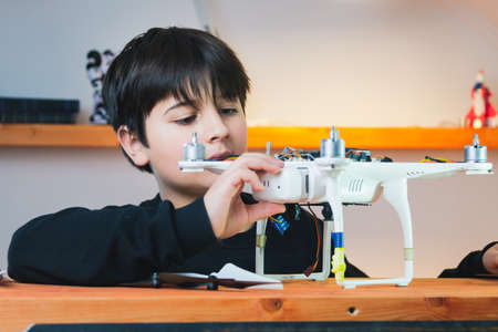 The teenager examines the drone he has assembled. Advanced Physics Model. Smart collaboration