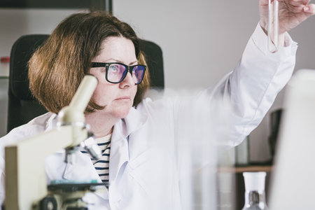 Adult female researcher studying insect behavior in a test tube. Research Laboratory. Biology of...