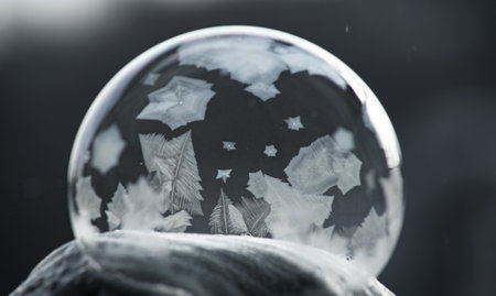 Winter collage. A transparent soap bubble freezing in the cold on a dark background. Tom 12.の写真素材