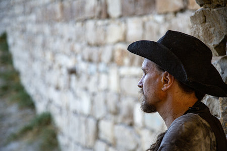 Emotional Portrait of a Man in traveler clothes and a hat against the backdrop of a breach in the...