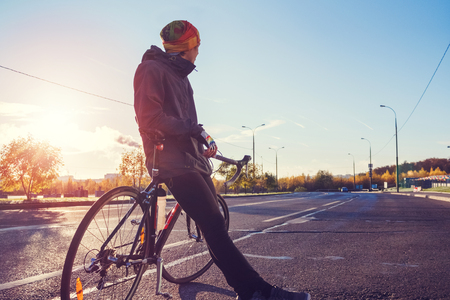 Cyclist with bicycle on an empty city streetの写真素材