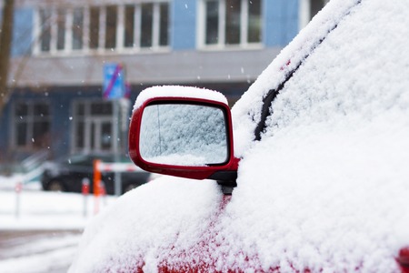 Snow-covered car on parking in winterの写真素材
