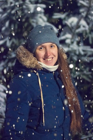 Young girl in the night winter forest