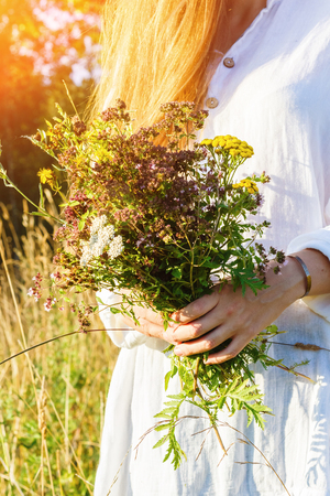 Woman holding a bouquet of wild flowersの写真素材