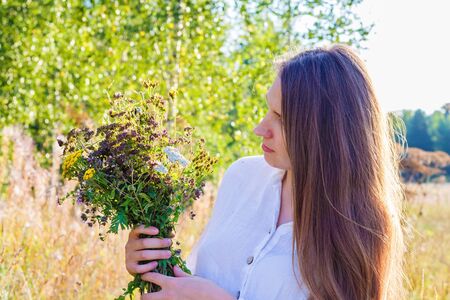 Portrait of a young girl with flowers in summerの写真素材