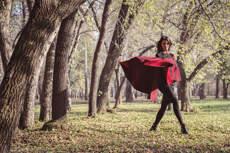 Model in autumn park with a red stoleの写真素材