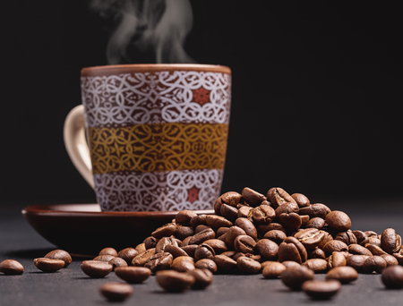 Coffee beans, cup of fresh coffee on black background.の写真素材