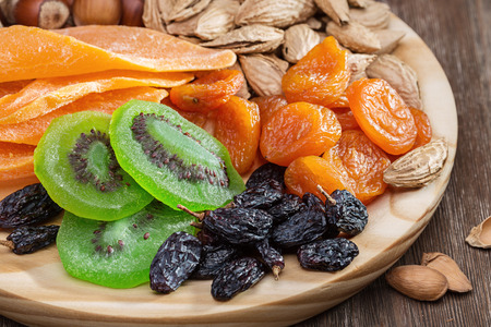 Dried fruits and nuts. Still life on a round wooden board.の写真素材