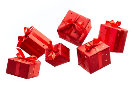 Surprise in flying boxes wrapped in red gift paper with bow on white background. Concept of holidays...